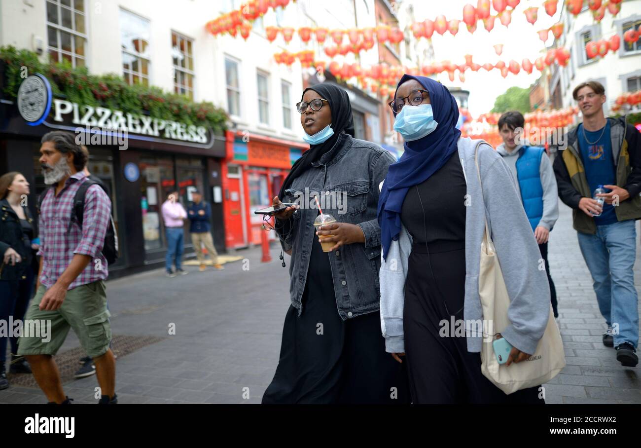 London, England, Großbritannien. Junge muslimische Frauen in Chinatown tragen Gesichtsmasken während der COVID-Pandemie, August 2020 Stockfoto