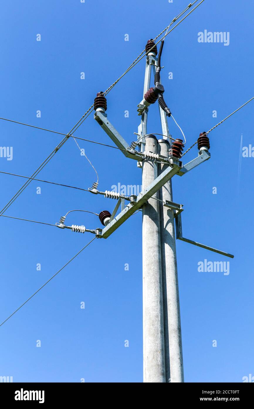 Energiekonzept. Hochspannungsmast-Stromleitungen gegen den blauen klaren Himmel. Dreiphasige Stromleitung zum Drehen. Stromverteilung. Stockfoto