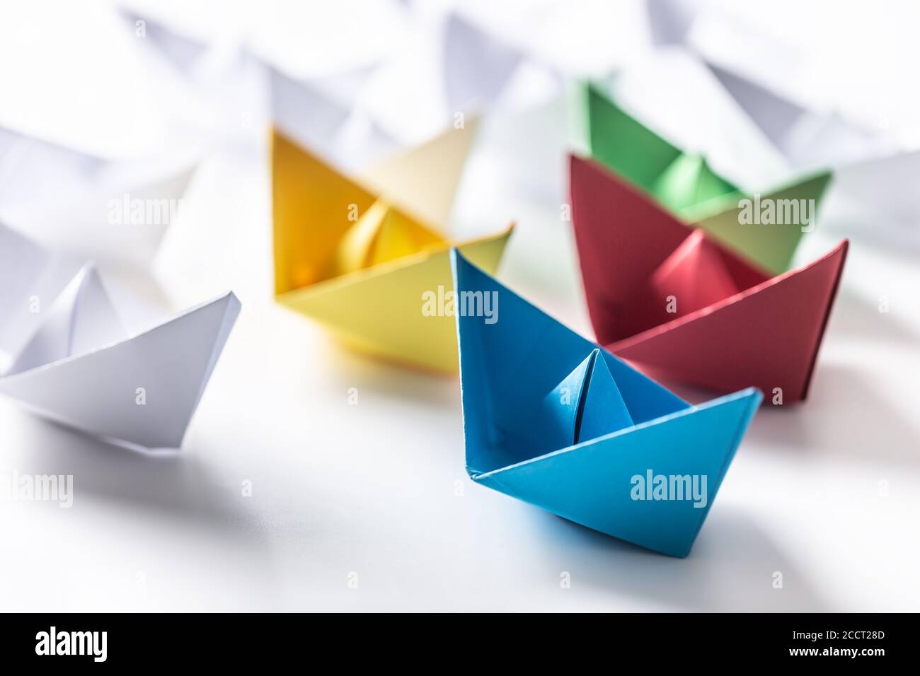 Mehrfarbige Papierboote. Konzept von Führungsbooten für Teamarbeit Gruppe oder Erfolg Stockfoto