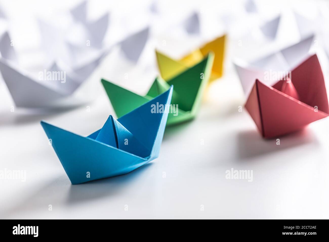 Mehrfarbige Papierboote. Konzept von Führungsbooten für Teamarbeit Gruppe oder Erfolg Stockfoto