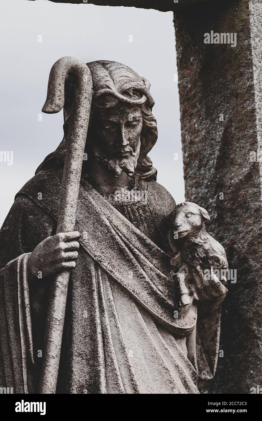 Dunkles Kontrastbild von Jesus Figur hält Baby Lamm und Shepard’s Gauner Stockfoto
