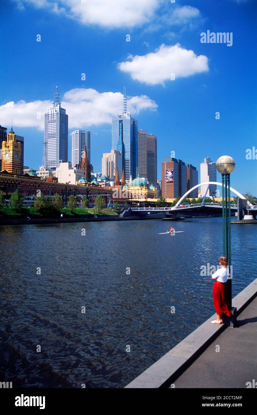 Lady mit Blick auf die Skyline der Innenstadt mit Brücke über den Yarra River von Melbourne aus. Victoria, Australien Stockfoto