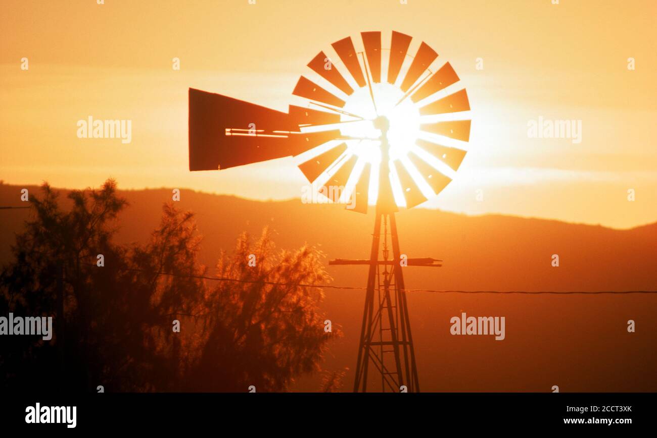 Alte Farm Windmühle Silhouetten in untergehenden Sonne über Nordamerika Stockfoto