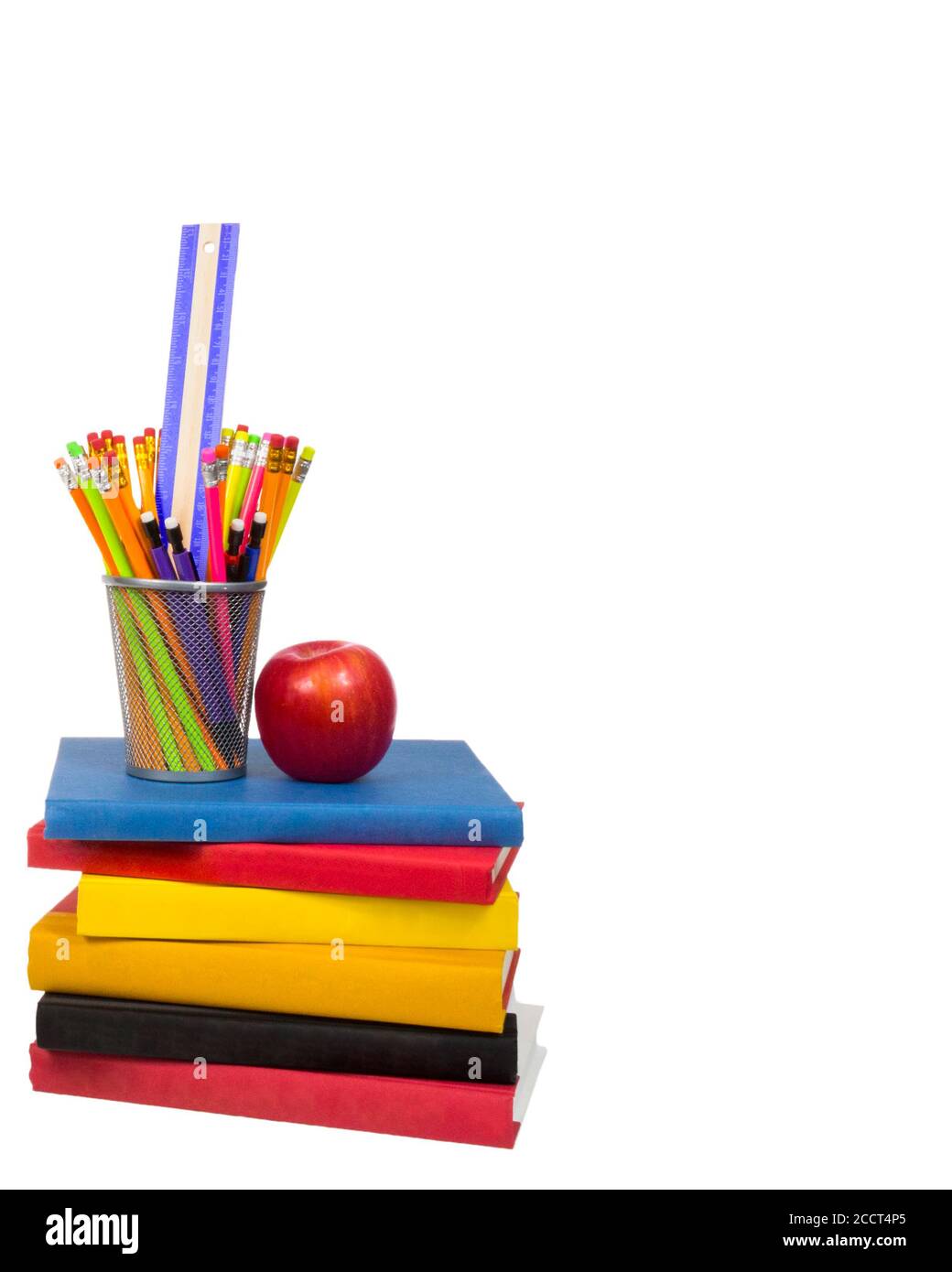 Vertikale Aufnahme eines Stapels von bunten Büchern mit einem Apfel und einem Drahtstifthalter auf der Oberseite sitzen. Bleistifthalter hält Bleistifte und ein Lineal. Isol Stockfoto