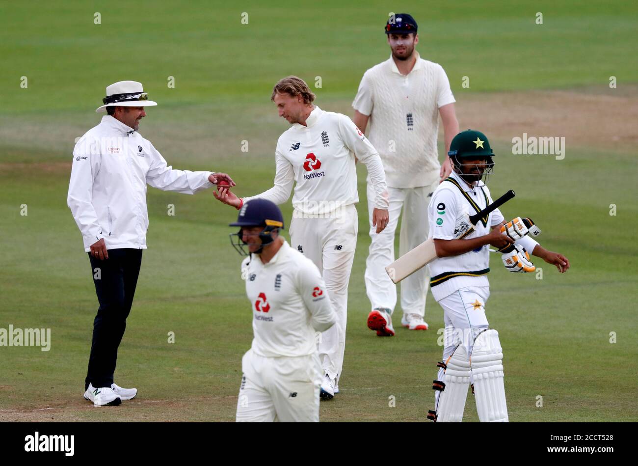 England Captain Joe Root (Mitte) gibt den Ball an einen Schiedsrichter zurück, da schlechtes Licht während des vierten Tages des dritten Testspiels im Ageas Bowl in Southampton nicht mehr spielt. Stockfoto