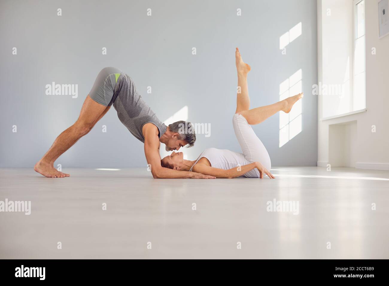 Sportliches Paar, das Partner Yoga praktiziert Stockfoto