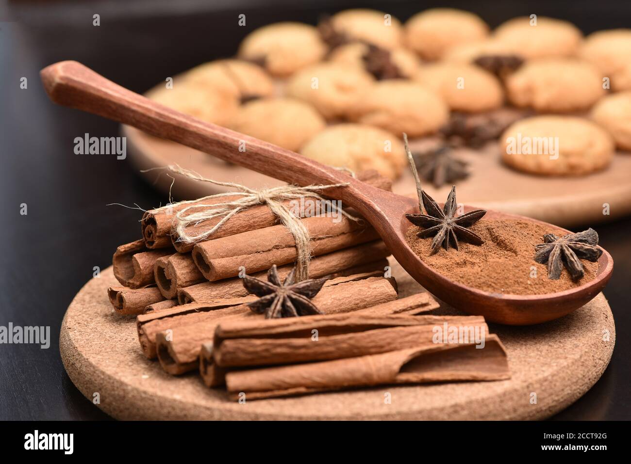 Traditionelle Weihnachtsgewürze - Sternanis mit Zimt und Nelken auf dunklem rustikalem Holzhintergrund Zimtrinde und Hammer und Kekse. Stockfoto