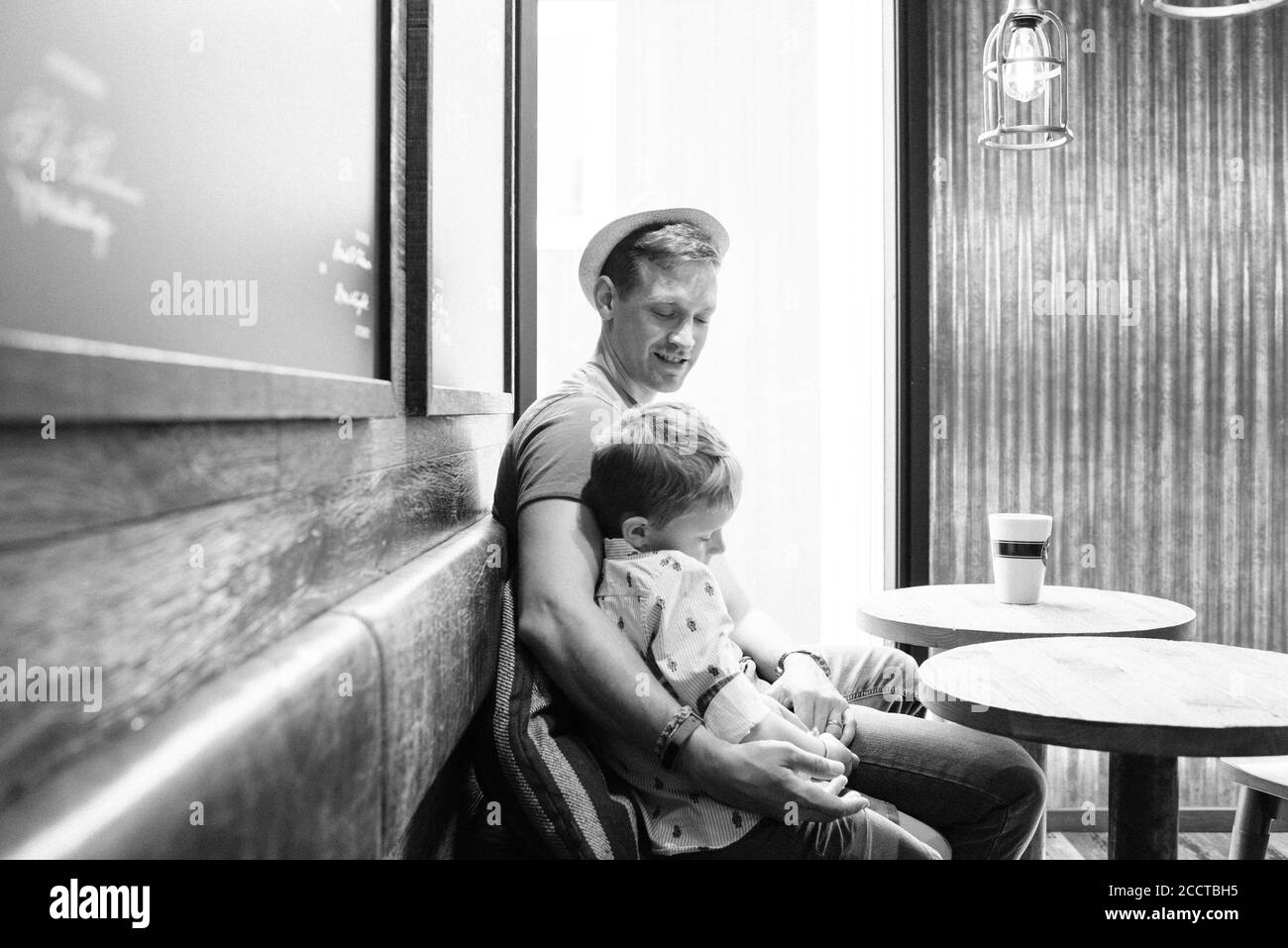 Vater saß kuscheln seinen Sohn während Kaffee trinken in einem Café Stockfoto