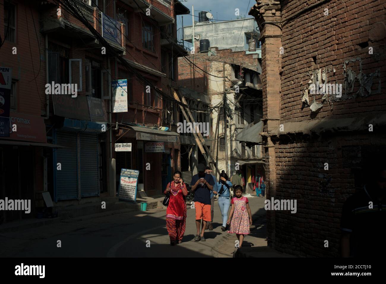 Bürger, die auf der Straße spazieren, durch ein Wohngebiet in Bhaktapur, Provinz Bagmati Pradesh, Nepal. Stockfoto