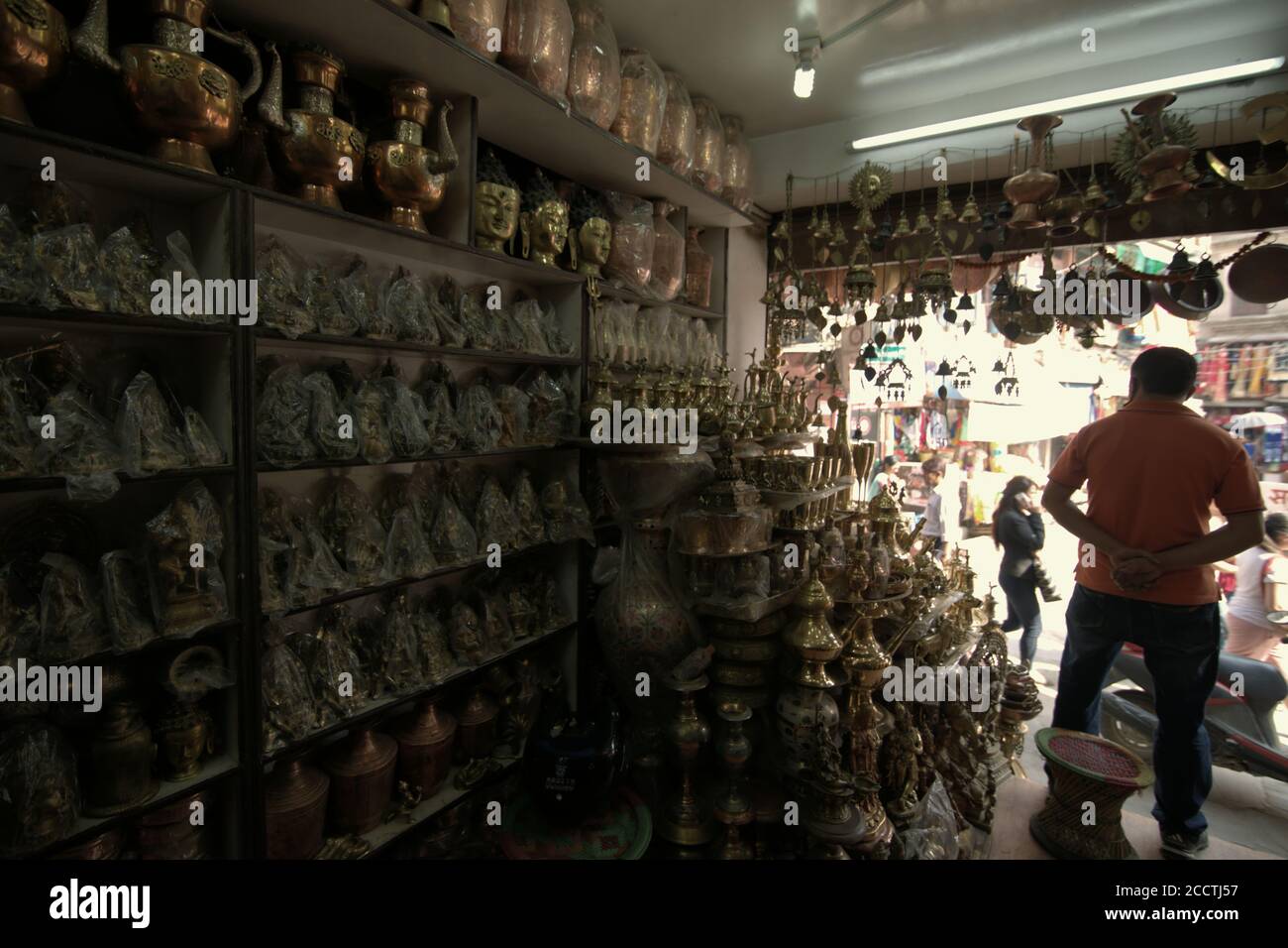 Ein Shopper wartet auf Kunden in einem Street Side Shop von Haus Ornament und Souvenirs in Thamel Gegend, Kathmandu, Nepal. Stockfoto