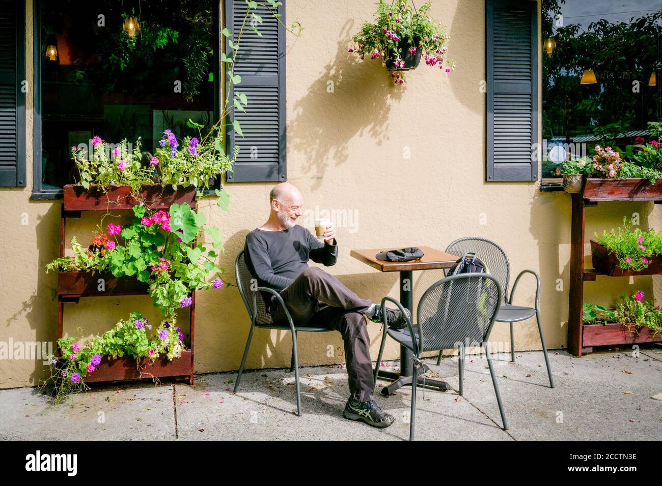 Mann, der die Terrasse im Artistry Coffee House and Bistro, Kitsilano, Vancouver, British Columbia, Kanada, genießt Stockfoto