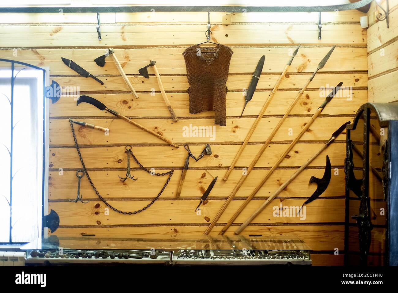Ring und verschiedene Geschütze hängen an einer Holzwand im Museum der Schmiedekunst. Stockfoto