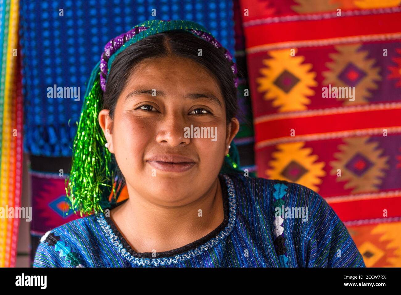 Eine Cakchiquel Maya-Frau in traditioneller Kleidung aus San Antonio Palopo in einem Webshop in Panajachel, Guatemala. Ihre blau gewebte Huipil Bluse ist Cha Stockfoto