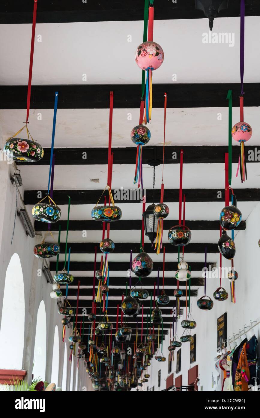 Bemalte Kürbisse hängen von der Arkade neben dem Hauptplatz von Chiapa de Corzo. Die Stadt ist berühmt für ihre bemalten Kürbishandarbeiten. Stockfoto