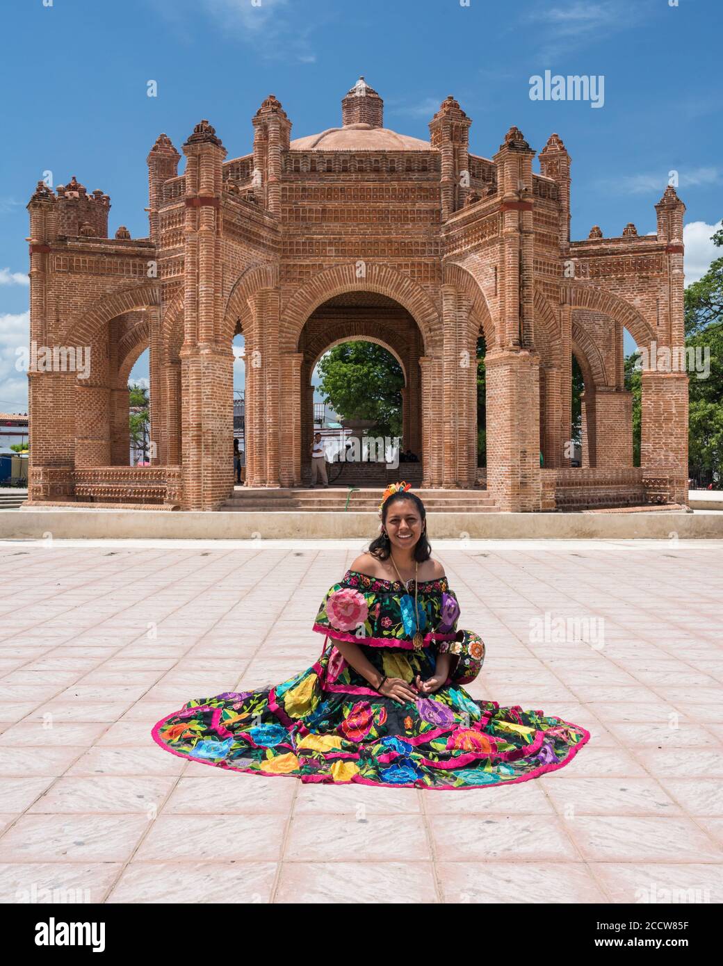 Eine junge Frau im typischen Tanzkostüm von Chiapa de Corzo posiert vor dem Brunnen La Pila. Chiapas, Mexiko. Stockfoto