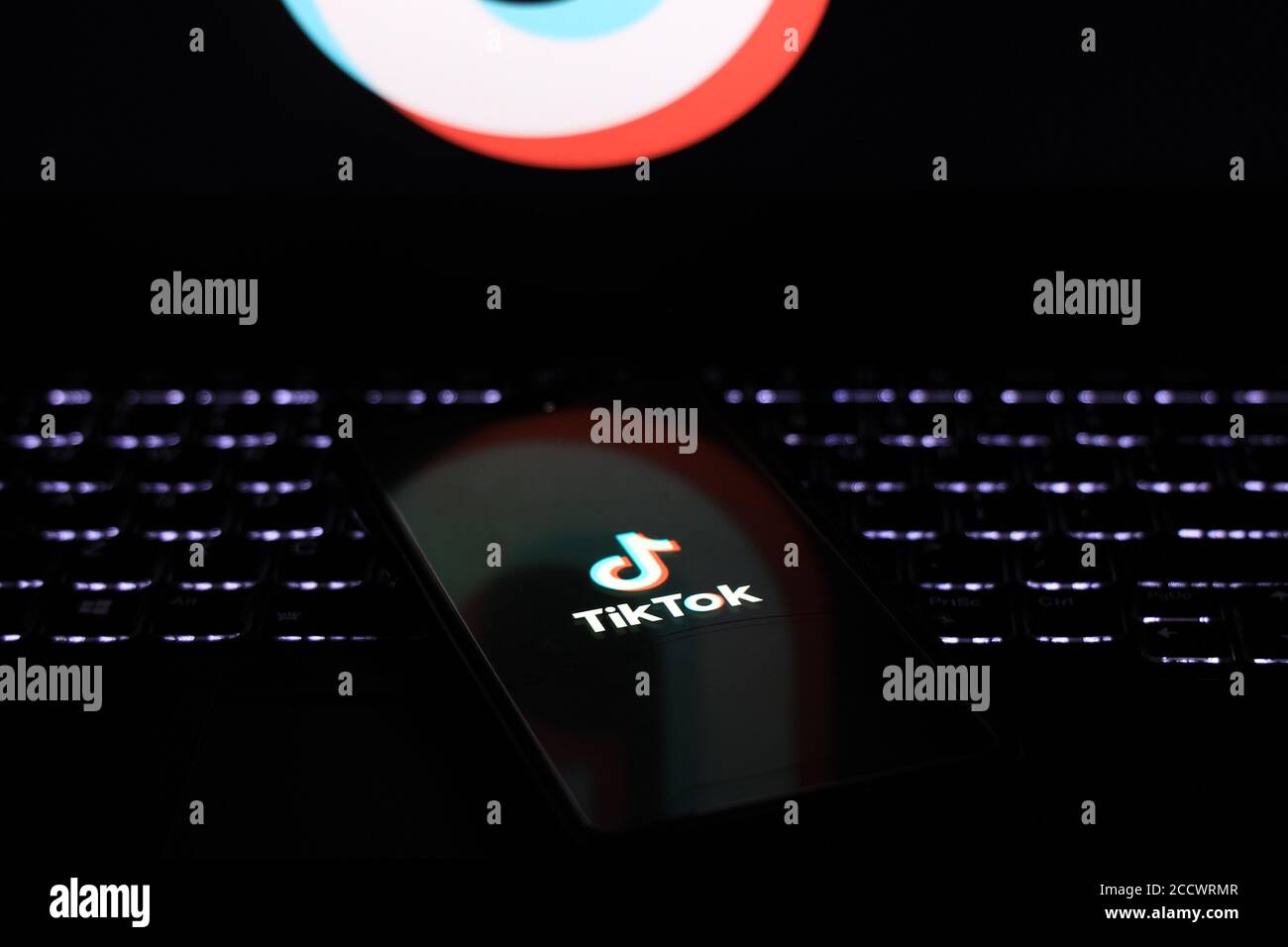 Bhairahawa, Nepal - August 25 2020: Telefon mit tiktok-Logo auf dem Bildschirm auf der Tastatur des Laptops im Dunkeln platziert. Stockfoto