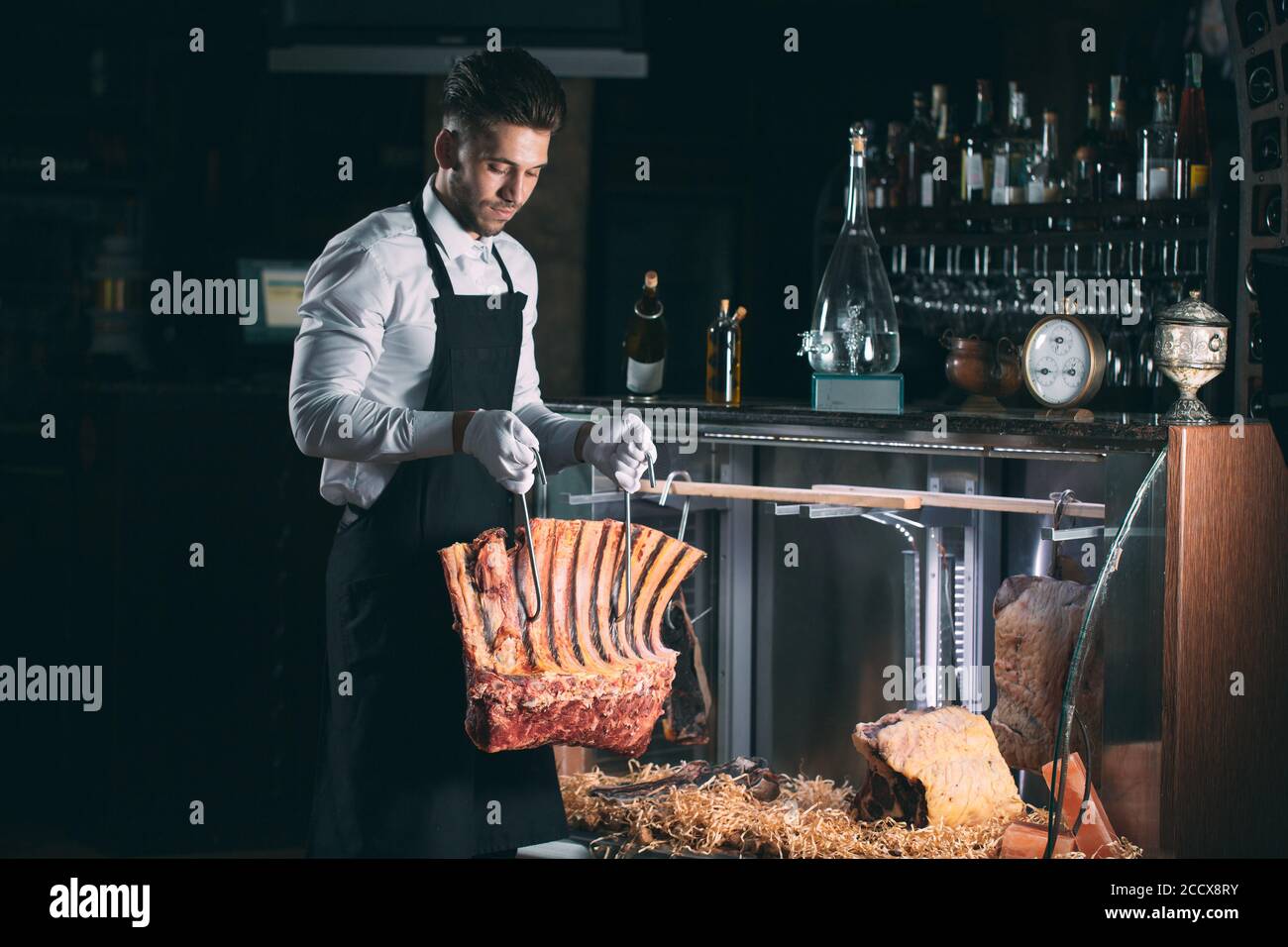 Der Kellner oder Koch bekommt trockenes Fleisch im Kühlschrank. Stockfoto