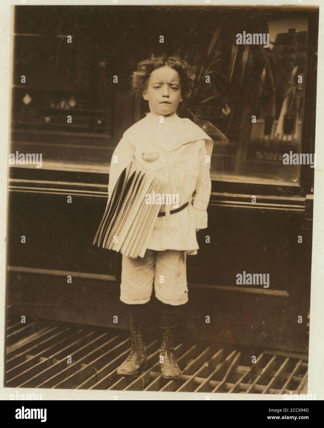 Jo. Lehman, ein 7-jähriger Zeitungsjunge. 824 Third Ave., New York City. Er verkaufte in diesem Salon. Ich fragte ihn nach dem Abzeichen, das er trug. „Oh! DAT's Me bruder', sagte er. Stockfoto
