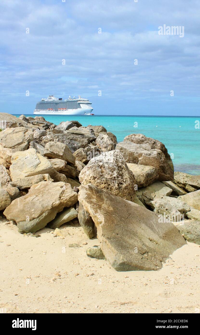 Das Kreuzfahrtschiff dockte in der Nähe eines felsigen Strandes in der Karibik an Stockfoto