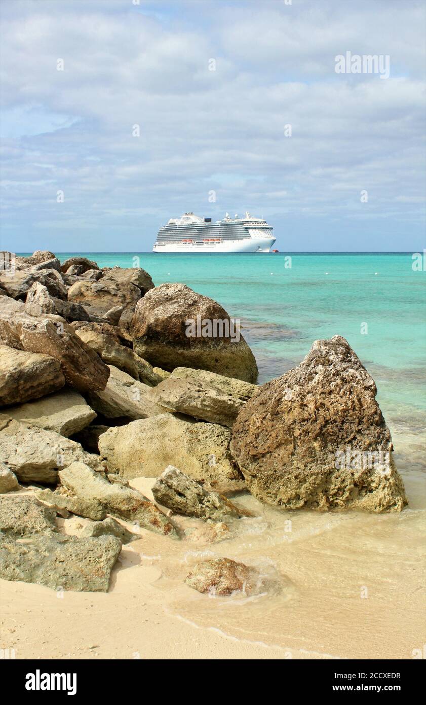 Das Kreuzfahrtschiff dockte in der Nähe eines felsigen Strandes in der Karibik an Stockfoto