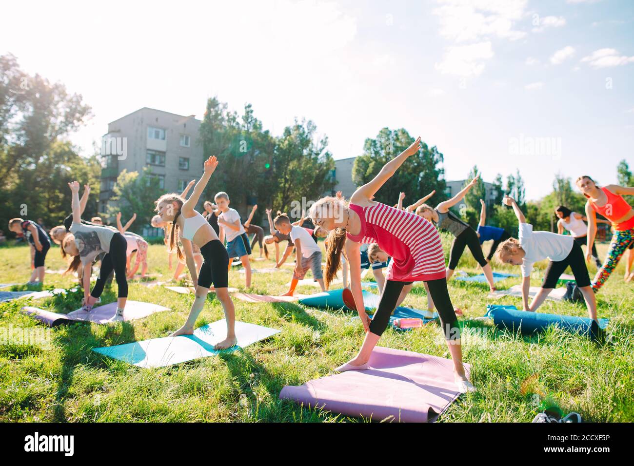 Yoga-Kurse draußen an der frischen Luft. Kinder Yoga, Stockfoto