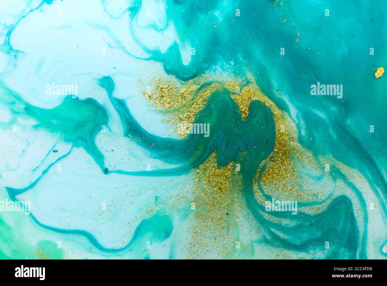 Buchstabe M auf flüssigem Marmor blau und Gold Hintergrund. Stockfoto