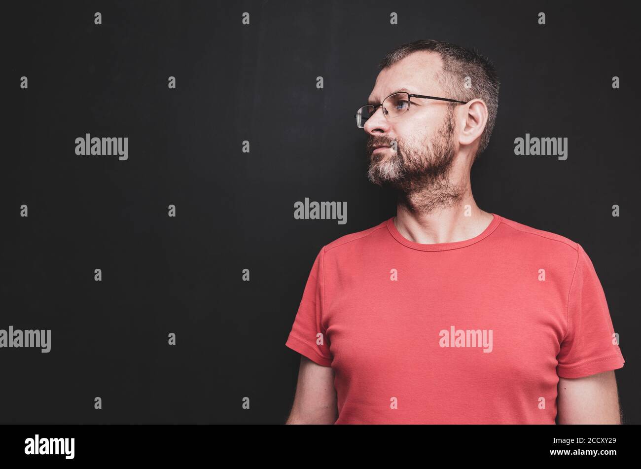 Ein Profilbild eines reifen Mannes mit gräulichem Haar Und Brillen vor schwarzem Wandhintergrund Stockfoto