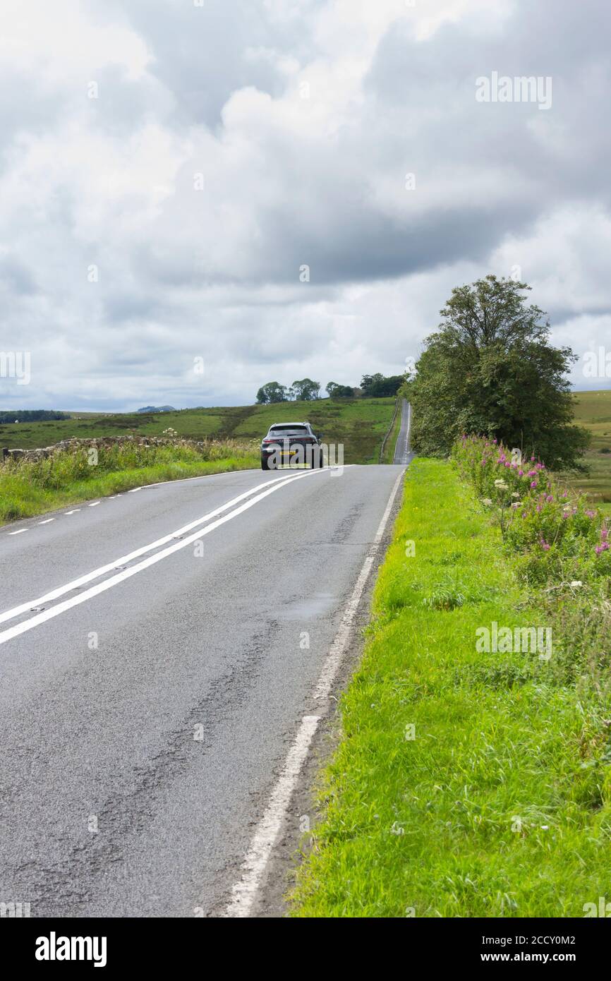Die B6318 Straße in Northumberland, lokal als "die Militärstraße" bekannt.die Straße ist es gerade für lange Abschnitte und grenzt an Hadrians Wall. Stockfoto