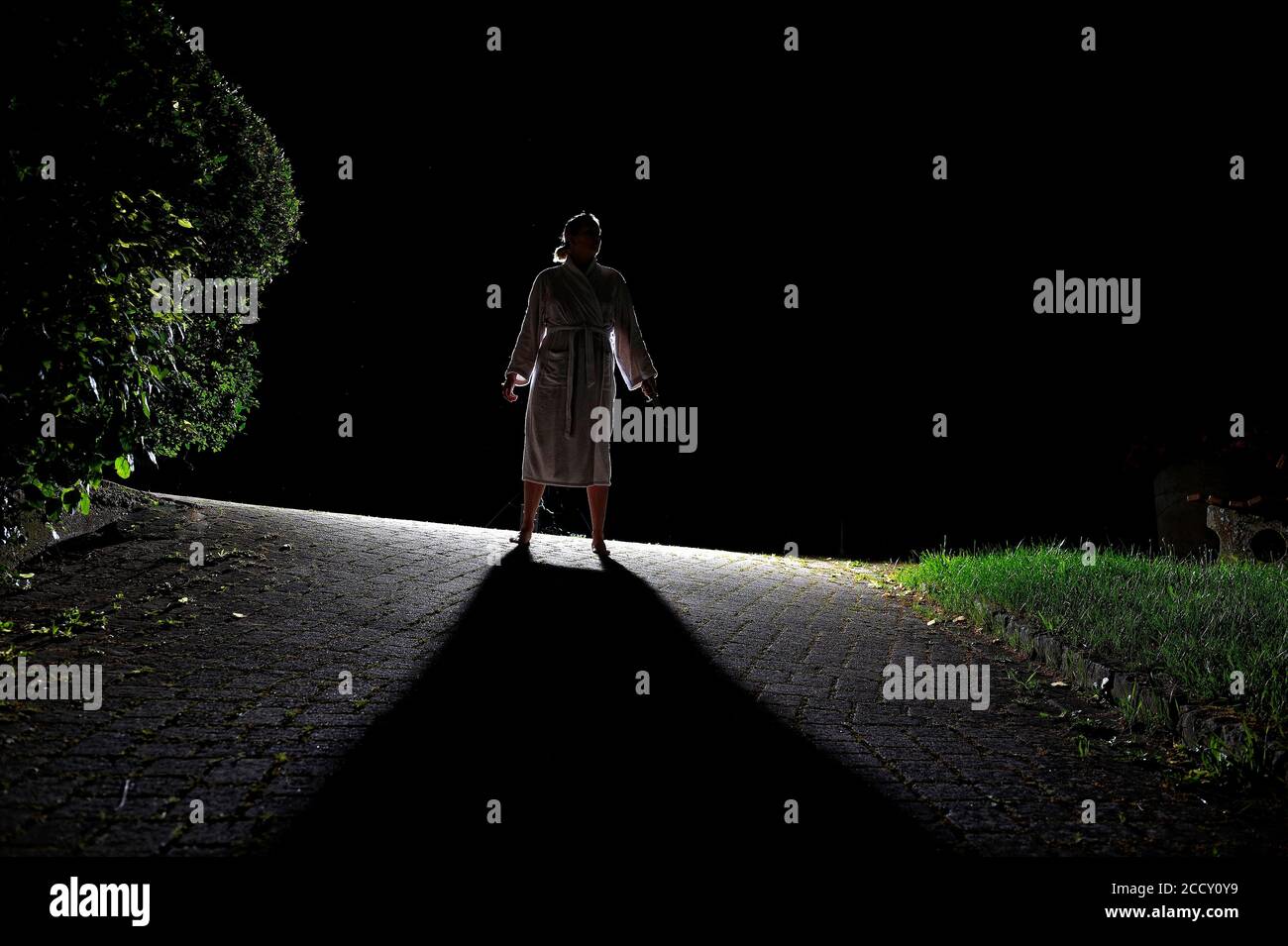 Thriller-Szene einer verängstigten Frau im Gegenlicht, geheimnisvolle Frau, Horrorszene des Gespensteres, mit schwarzen Schatten, Deutschland Stockfoto