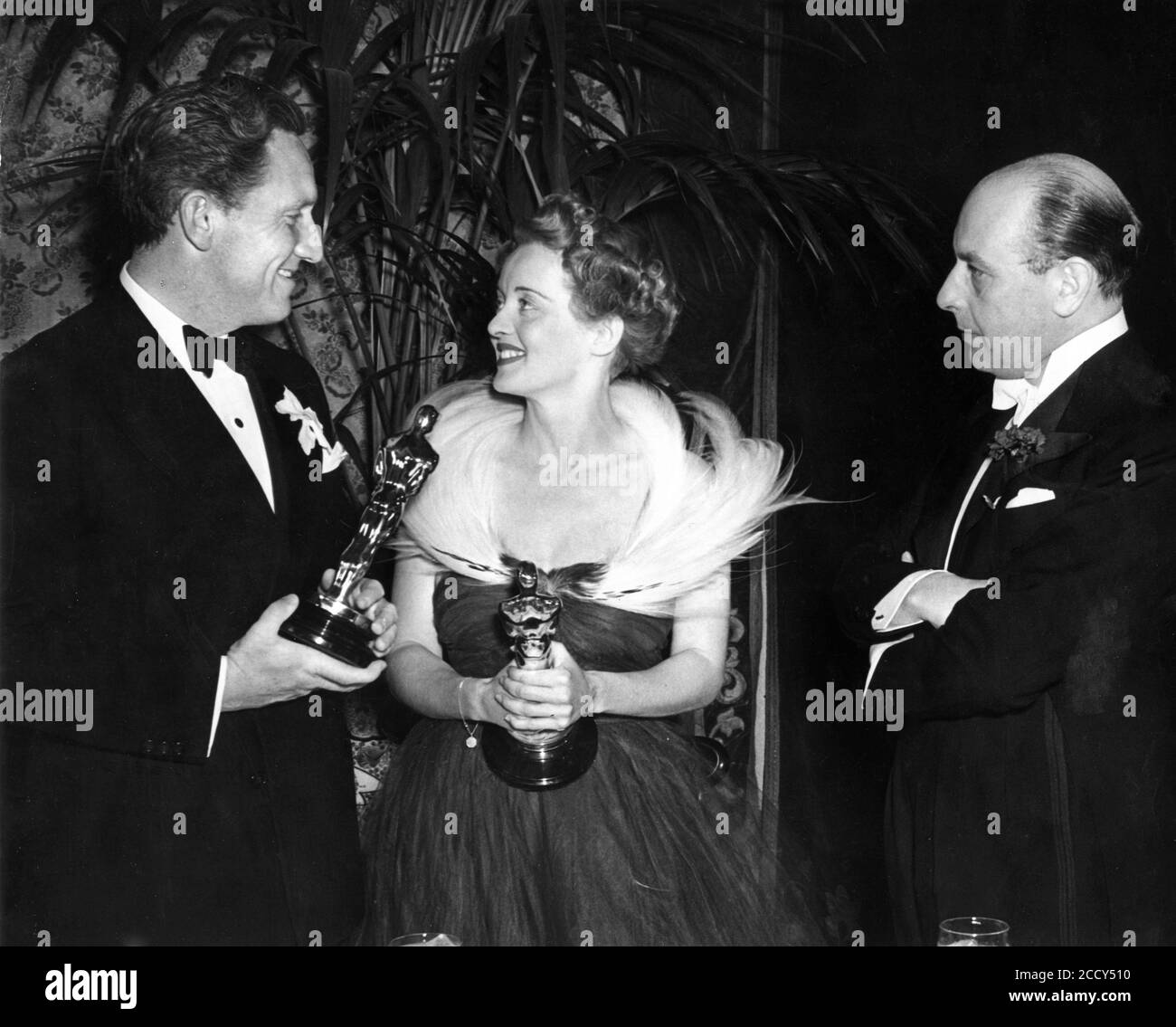 SPENCER TRACY mit seinem besten Darsteller Oscar für BOYS TOWN Und BETTE DAVIS hält ihren Oscar für die beste Schauspielerin von 1938 für JEZEBEL bei der Oscar-Verleihung 1939 in Das Biltmore Hotel in Los Angeles 23. Februar 1939 mit CEDRIC HARDWICKE, der die Preise überreichte Stockfoto