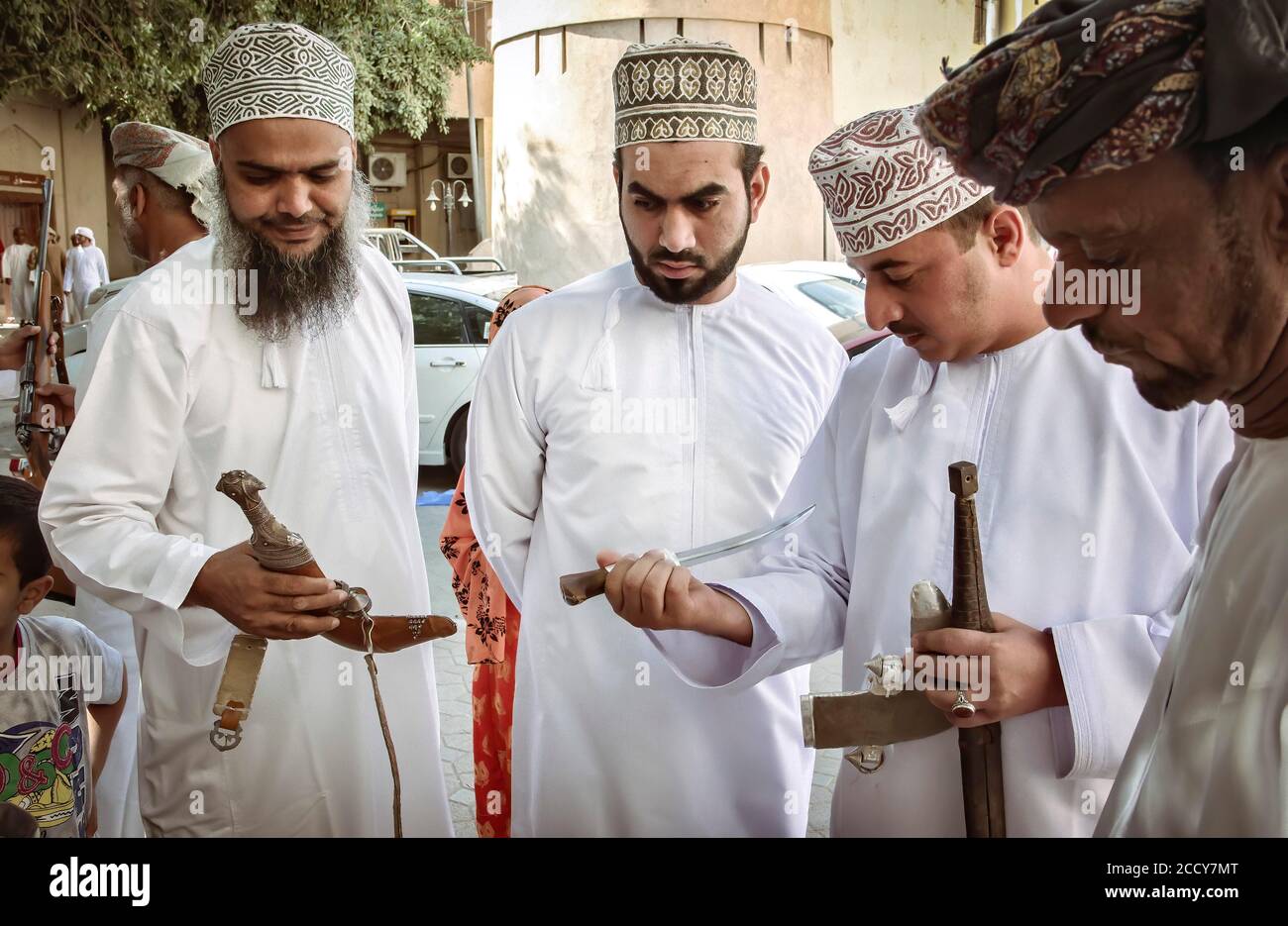 Die Einheimischen untersuchen Silberdagger auf dem Waffenmarkt, Nizwa, Oman Stockfoto