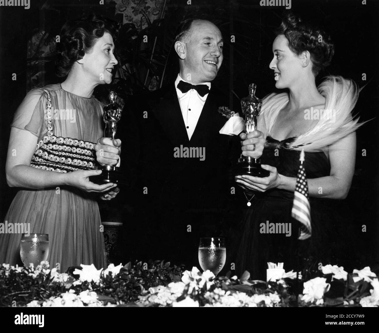 FAY BAINTER mit ihrer besten Nebendarstellerin Oscar für JEZEBEL und BETTE DAVIS mit ihrem Oscar für die Beste Darstellerin von 1938 für JEZEBEL bei der Academy Award Ceremony 1939 im Biltmore Hotel in Los Angeles 23. Februar 1939 mit ihrem Chef JACK L. WARNER Warner Bros. Vice - President Verantwortlich für die Produktion Stockfoto