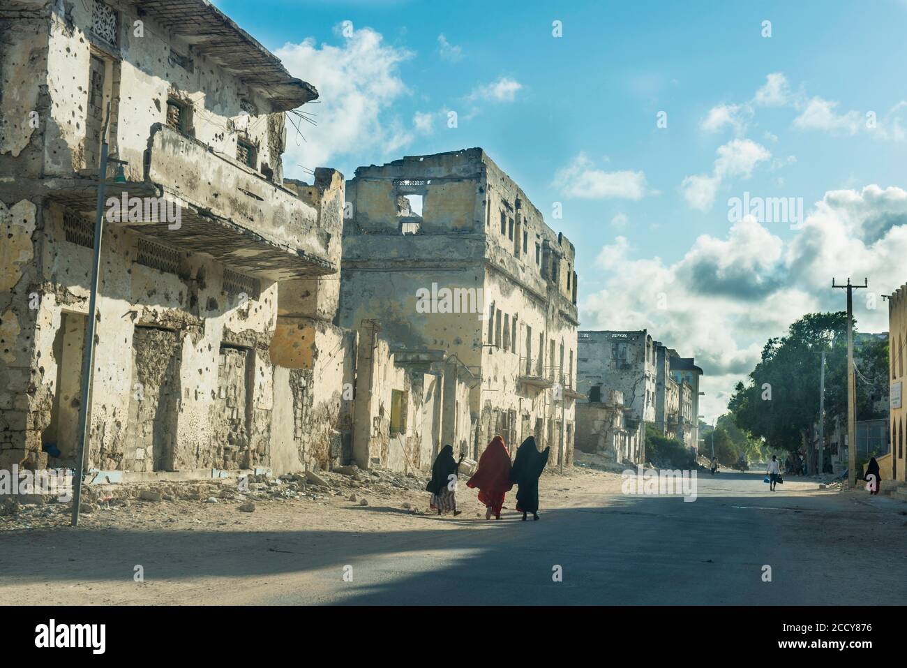 Somalische Frauen, die durch die Straßen der zerstörten Häuser von Mogadischu, Somalia, gehen Stockfoto