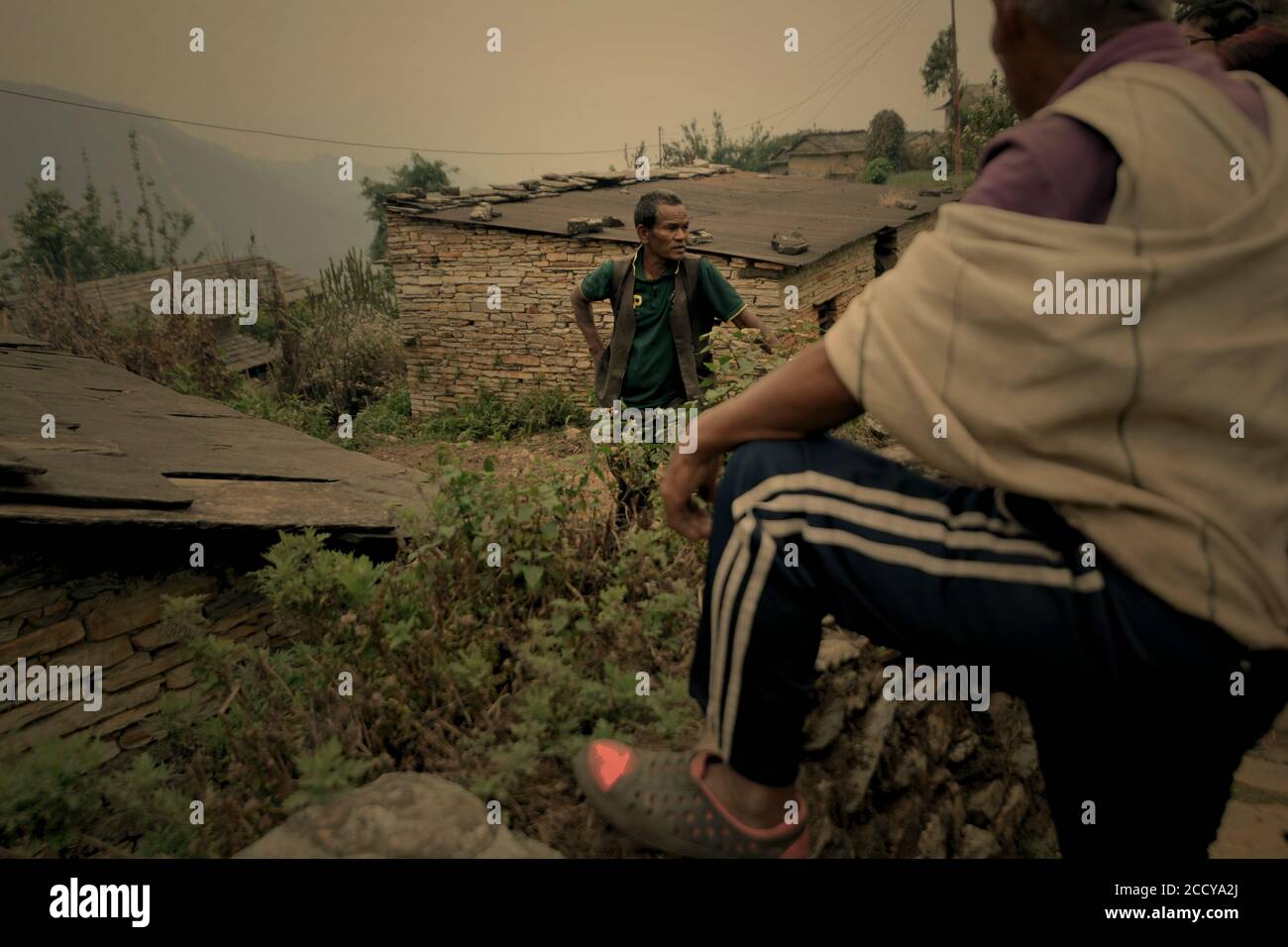 Ein Bauer im Gespräch mit Besuchern im landwirtschaftlichen Dorf Damdame in Panchase Bergregion, Kaski, Gandaki Pradesh, Nepal. Stockfoto