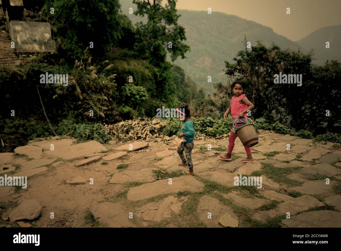 Kinder, die Wasser aus einer kommunalen Wasserquelle in Panchase Region, Provinz Gandaki Pradesh, Nepal, holen wollen. Stockfoto