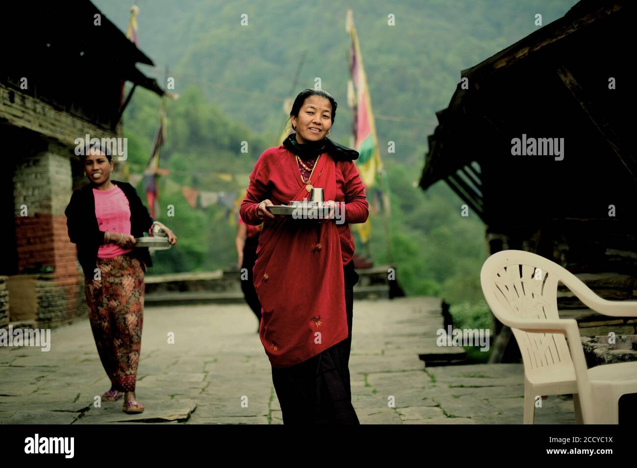 Dorfbewohner bringen Mahlzeiten für Besucher in Sidhane Dorf in Panchase Bergregion, Kaski, Gandaki Pradesh, Nepal. Stockfoto