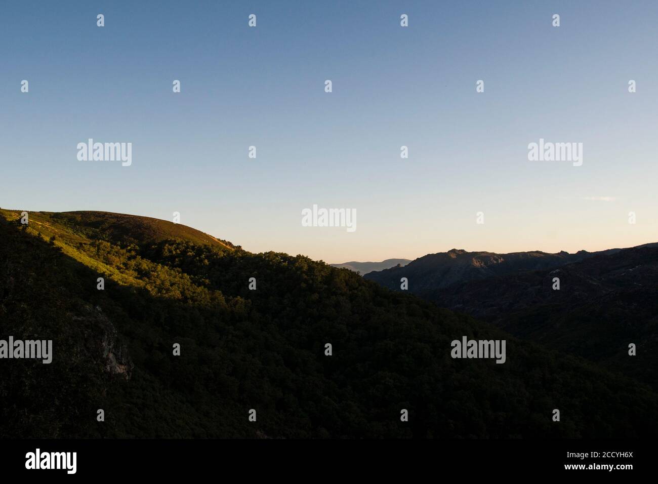 Berge Formen verschwinden allmählich am Horizont bei Sonnenuntergang. Weiche Schatten und goldenes Licht. Stockfoto