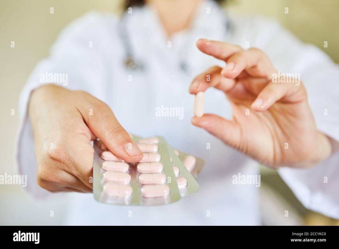 Ärztin zeigt eine einzelne Tablette und eine Blisterpackung Als neue Droge Stockfoto