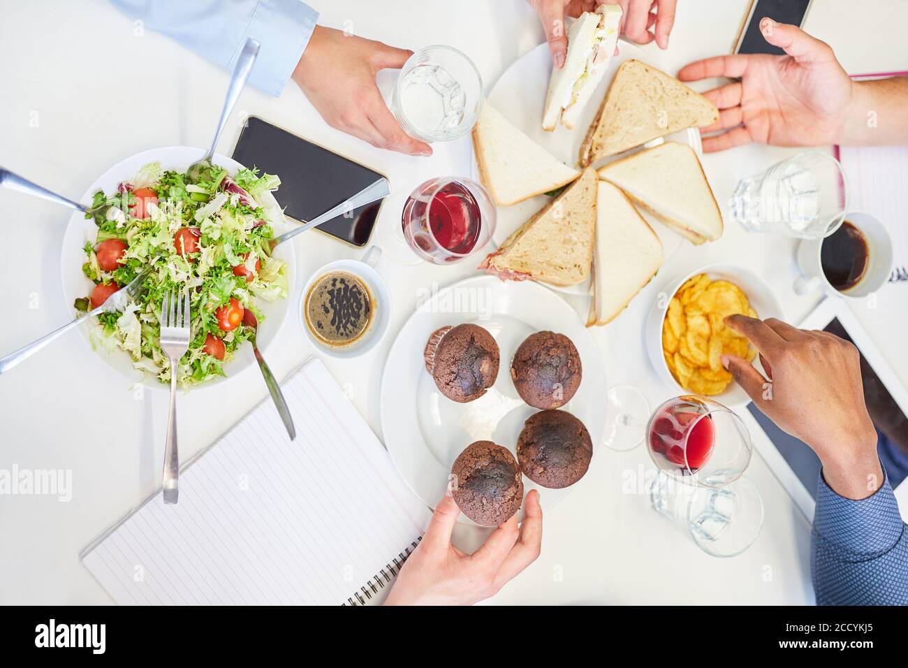 Die Kollegen des Geschäftsteams teilen sich beim Mittagessen im verschiedene Snacks Büro Stockfoto