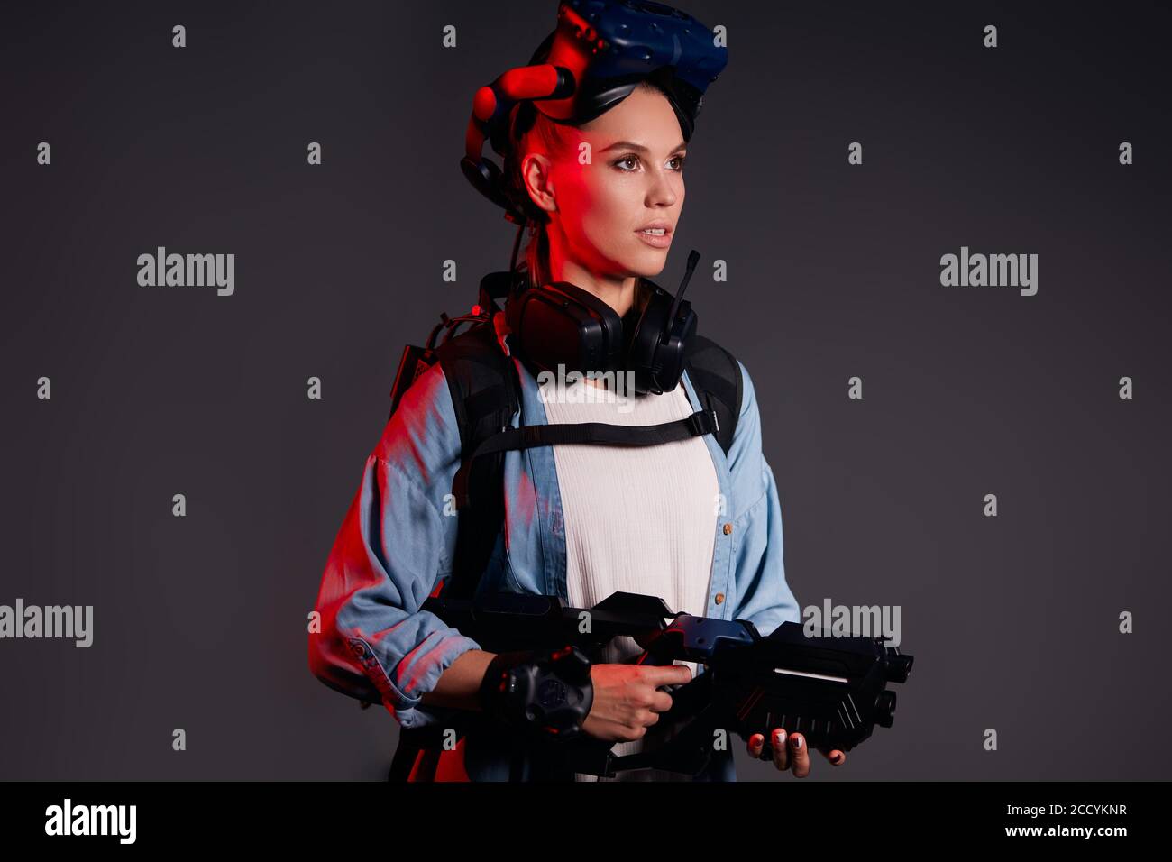 Augmented Reality, Hi-Tech, Spiel, Hobby-Konzept. Junge kaukasische Mädchen  hält VR-Waffe, trägt spezielle Maske auf dem Kopf, UV-Strahlen auf ihrer  Kleidung Stockfotografie - Alamy