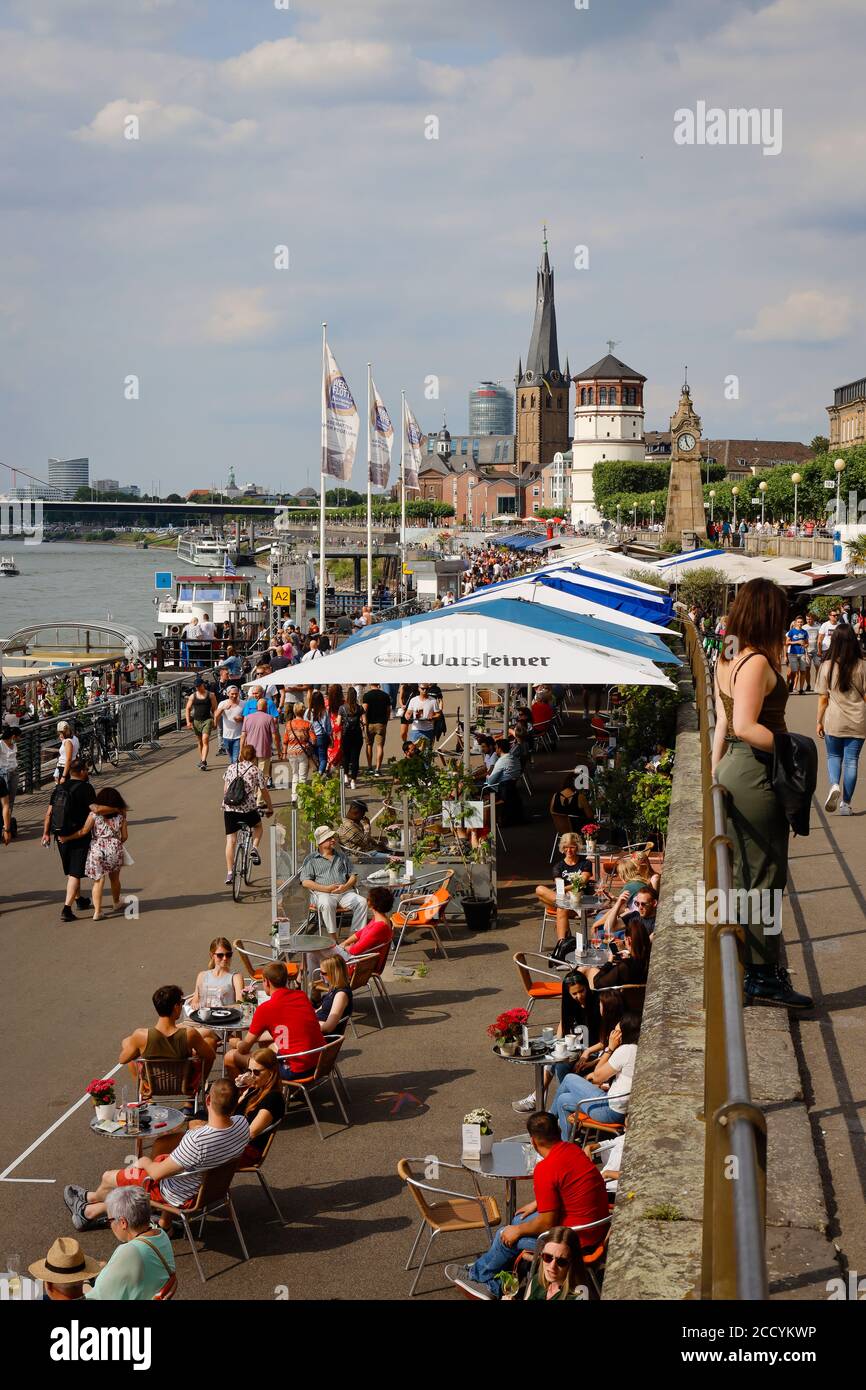 Düsseldorf, Nordrhein-Westfalen, Deutschland - Rheinuferpromenade in Zeiten der Corona-Pandemie laufen die Menschen am Rheinufer entlang und sitzen im c Stockfoto
