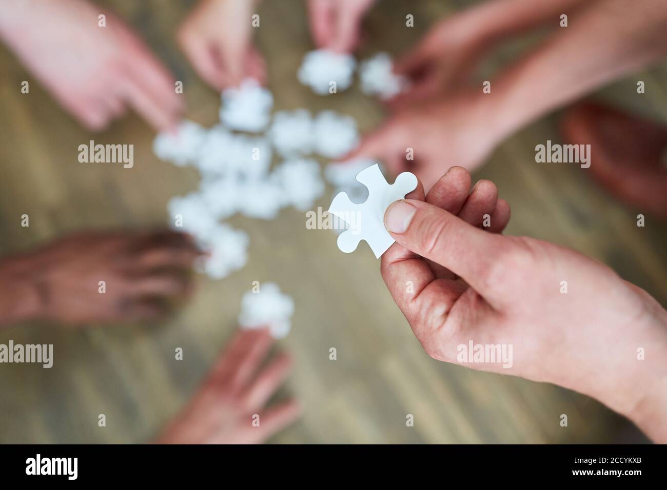 Puzzle-Stück in der Hand eines Geschäftsmannes in der Workshop zum Aufbau von Geschäftsteams Stockfoto