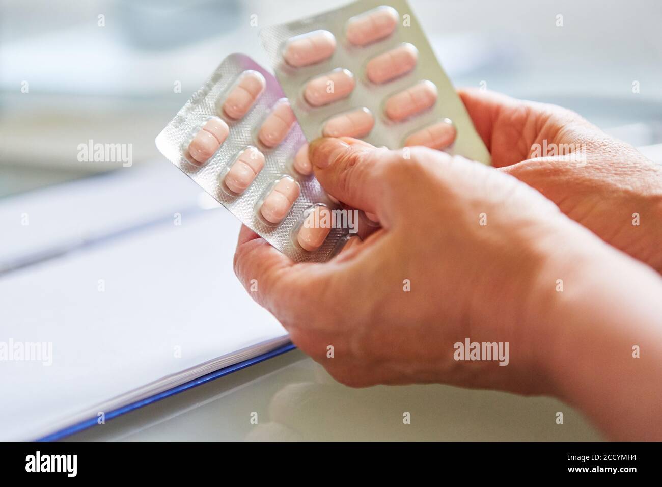 Arzt hält Blisterpackung als Medizin in beiden Händen Beratung Stockfoto