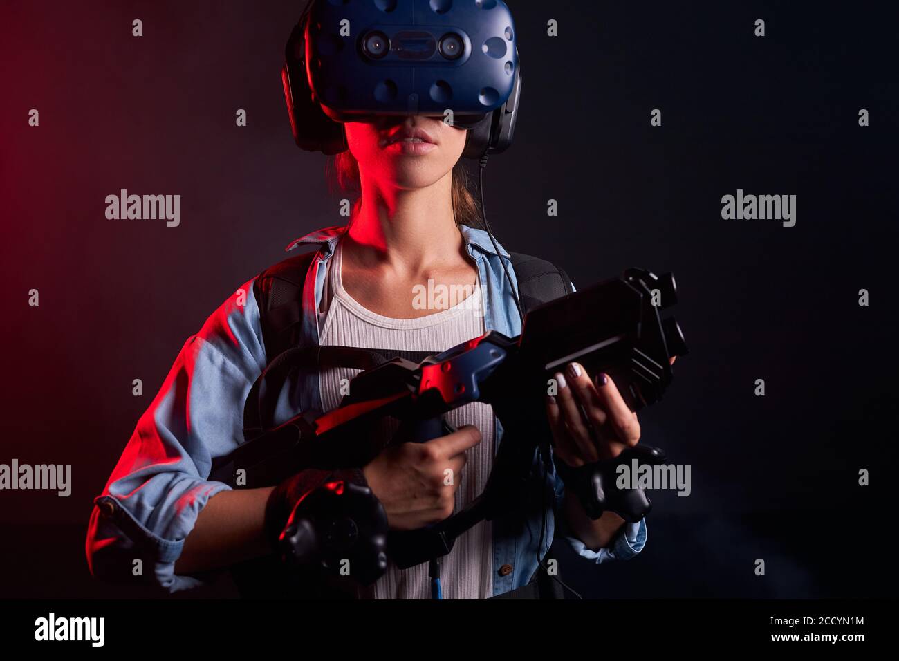Isolierter Shoot der jungen Frau Spiel mit VR-Waffe, speacial Maske auf dem Kopf. Ultraviolett Stockfoto