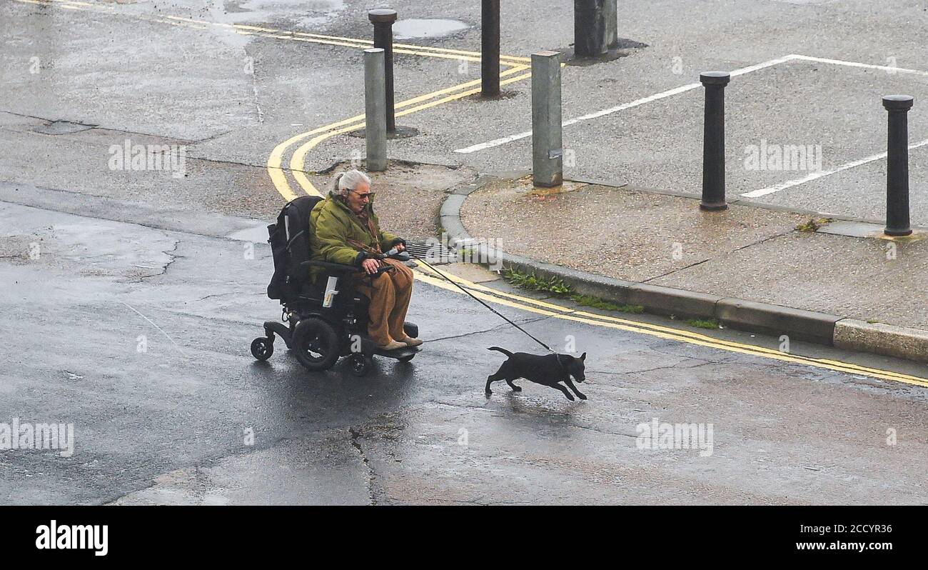 Brighton UK 25. August 2020 - Dieses Paar kämpft gegen die starken Winde und den Regen entlang der Küste von Brighton, während Sturm Francis heute durch Großbritannien fegt : Credit Simon Dack / Alamy Live News Stockfoto