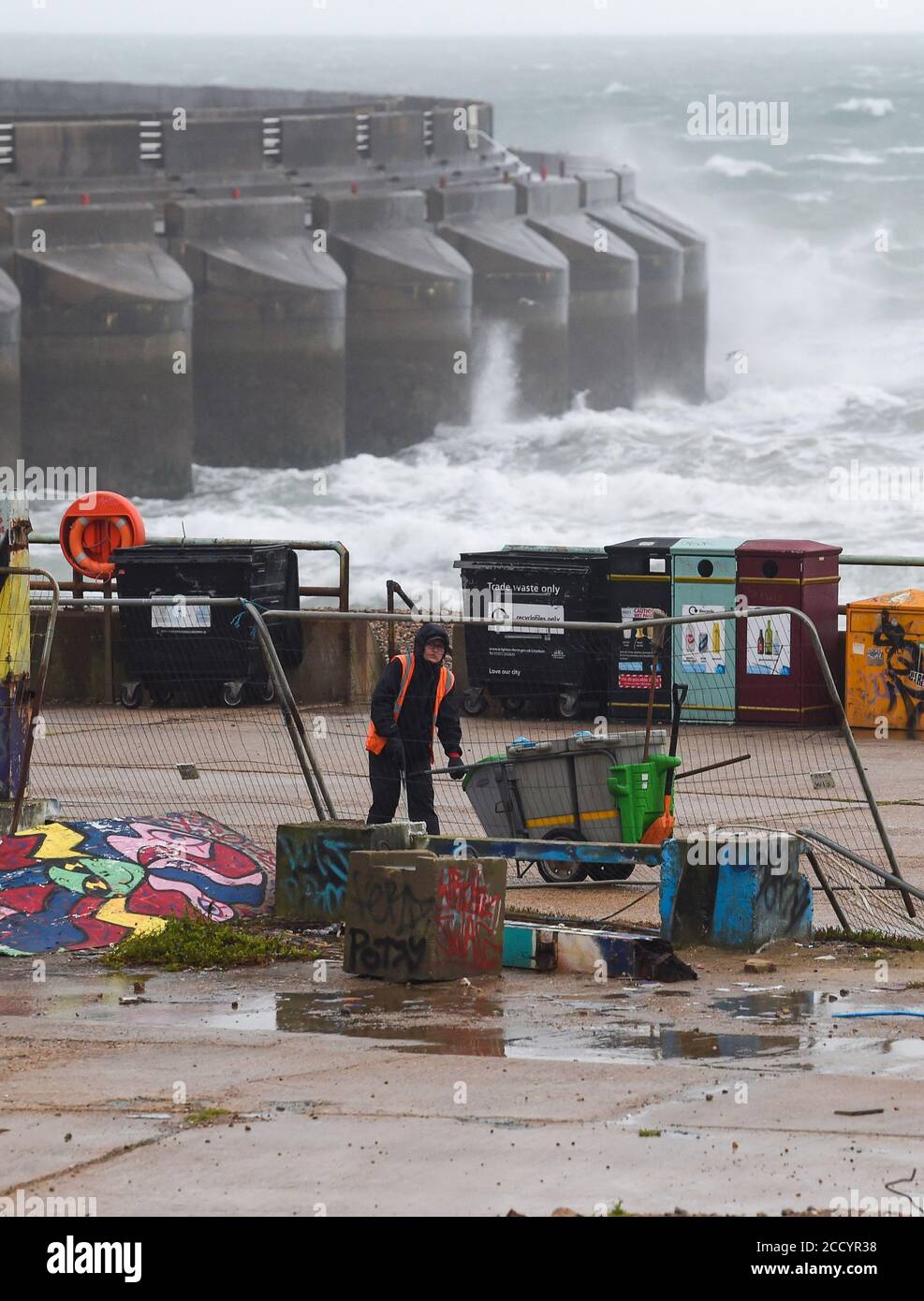 Brighton UK 25. August 2020 - EIN ratsarbeiter kämpft bei nassem und windigem Wetter am Black Rock in Brighton gegen die Elemente, während Sturm Francis heute durch Großbritannien fegt : Credit Simon Dack / Alamy Live News Stockfoto