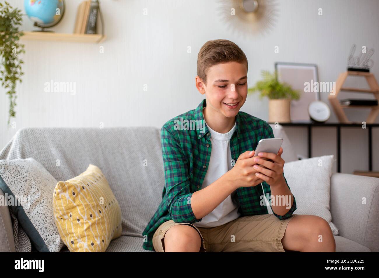 Glücklich teen Kerl chatten mit Freunden, mit Smartphone Stockfoto