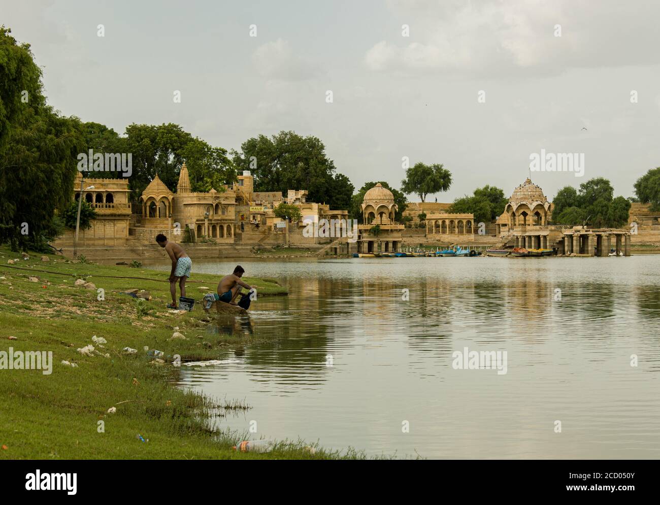 Zwei Männer baden und waschen Kleidung im See Stockfoto