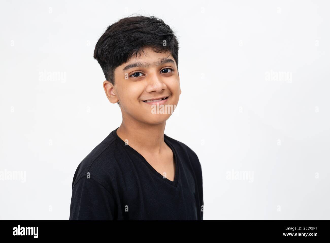 Nahaufnahme Bild von einem niedlichen indischen Jungen. Entzückender Teenager steht vor weißem Hintergrund Stockfoto