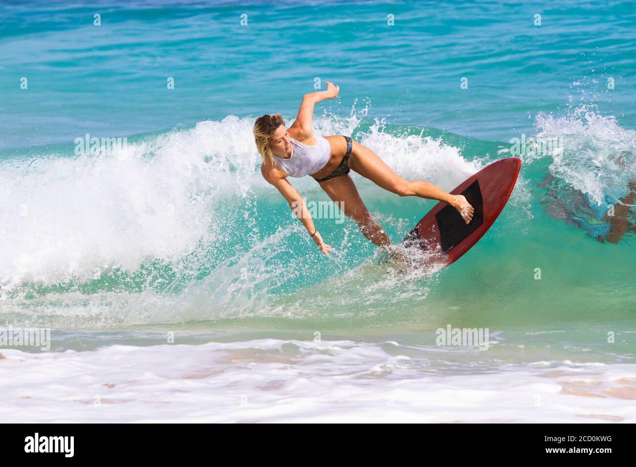 Eine junge Frau, die auf einer Welle vor Sandy Beach, Oahu, Oahu, Hawaii, Vereinigte Staaten von Amerika abrutscht Stockfoto
